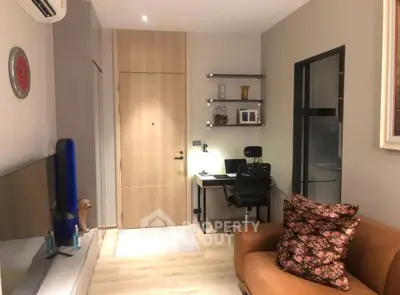 Modern living room with cozy sofa, wall-mounted TV, and stylish workspace in a compact apartment.