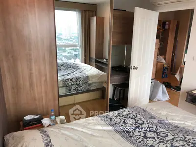 Cozy bedroom with mirrored wardrobe and city view window, perfect for urban living.