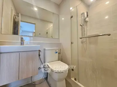 Modern bathroom with glass shower and sleek fixtures in a contemporary apartment.