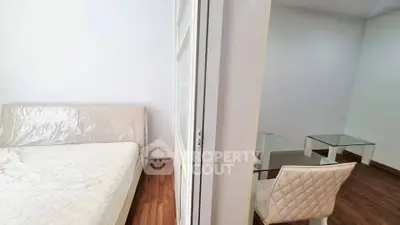 Modern apartment with cozy bedroom and stylish dining area, featuring wooden flooring and elegant furniture.