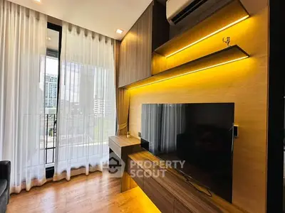 Modern living room with large TV, wooden accents, and floor-to-ceiling windows offering city views.