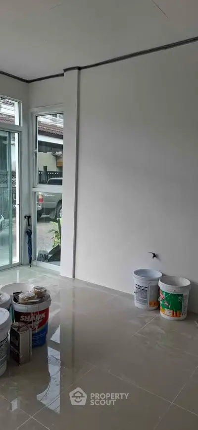 Bright interior space with large windows and renovation materials, ideal for customization.