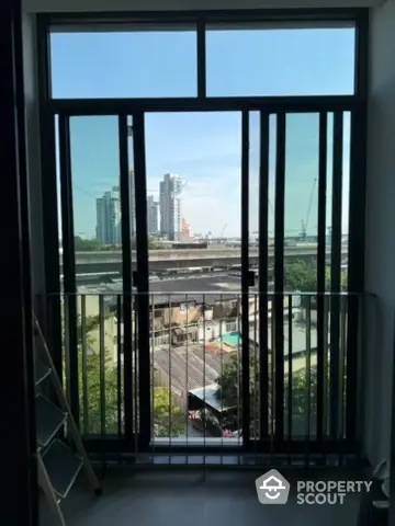 Modern apartment window with city view and balcony access