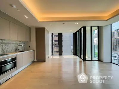 Luxurious modern apartment with open kitchen and stunning city view, featuring sleek design and ample natural light.