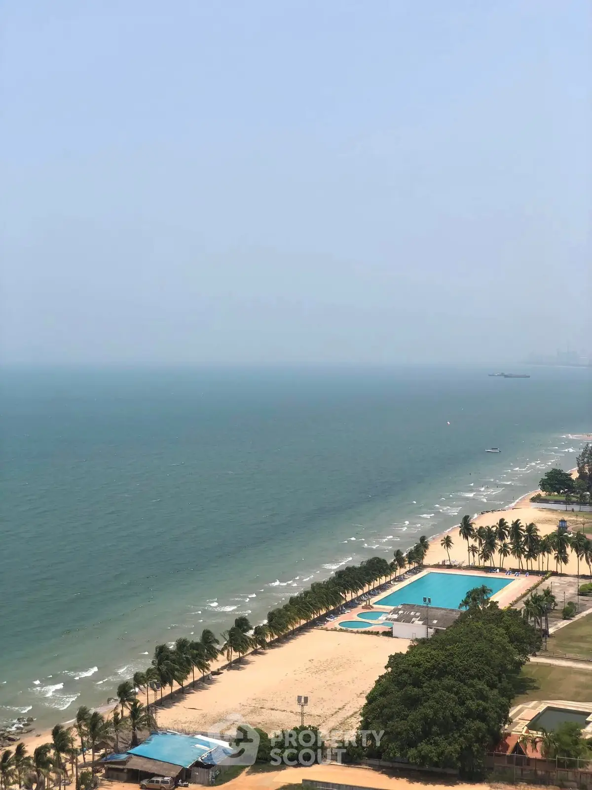 Stunning beachfront view with palm-lined shore and ocean horizon.
