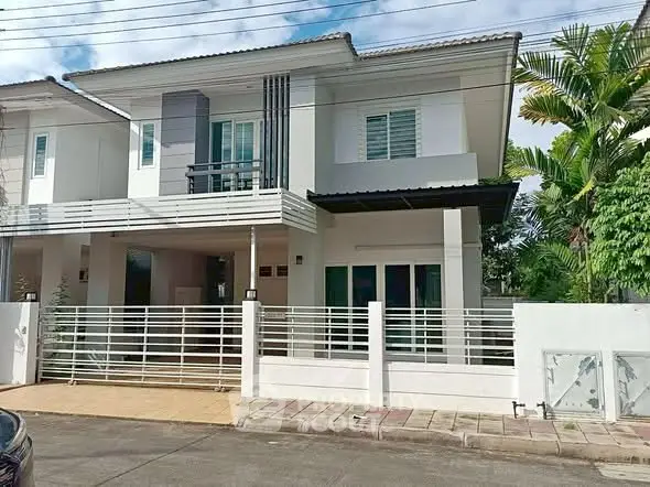 Modern two-story house with sleek design and spacious front yard in a suburban neighborhood.
