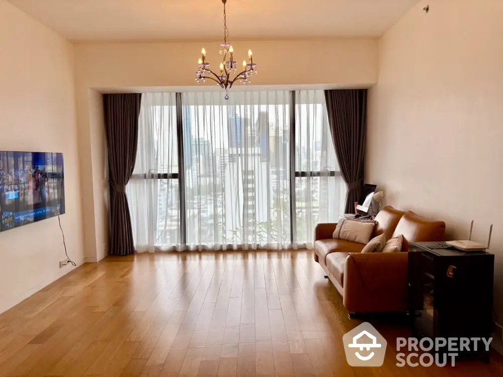 Spacious living room with city view and elegant chandelier