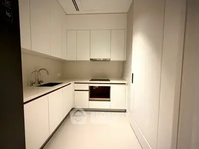 Modern minimalist kitchen with sleek white cabinetry and built-in appliances