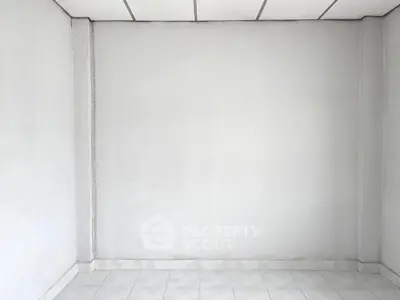 Minimalist empty room with white walls and tiled floor, perfect for customization.