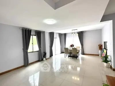 Spacious modern living room with elegant dining area and large windows for natural light.