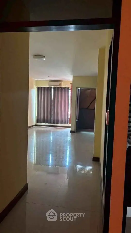 Spacious empty living room with large window and glossy tiled floor, perfect for customization.