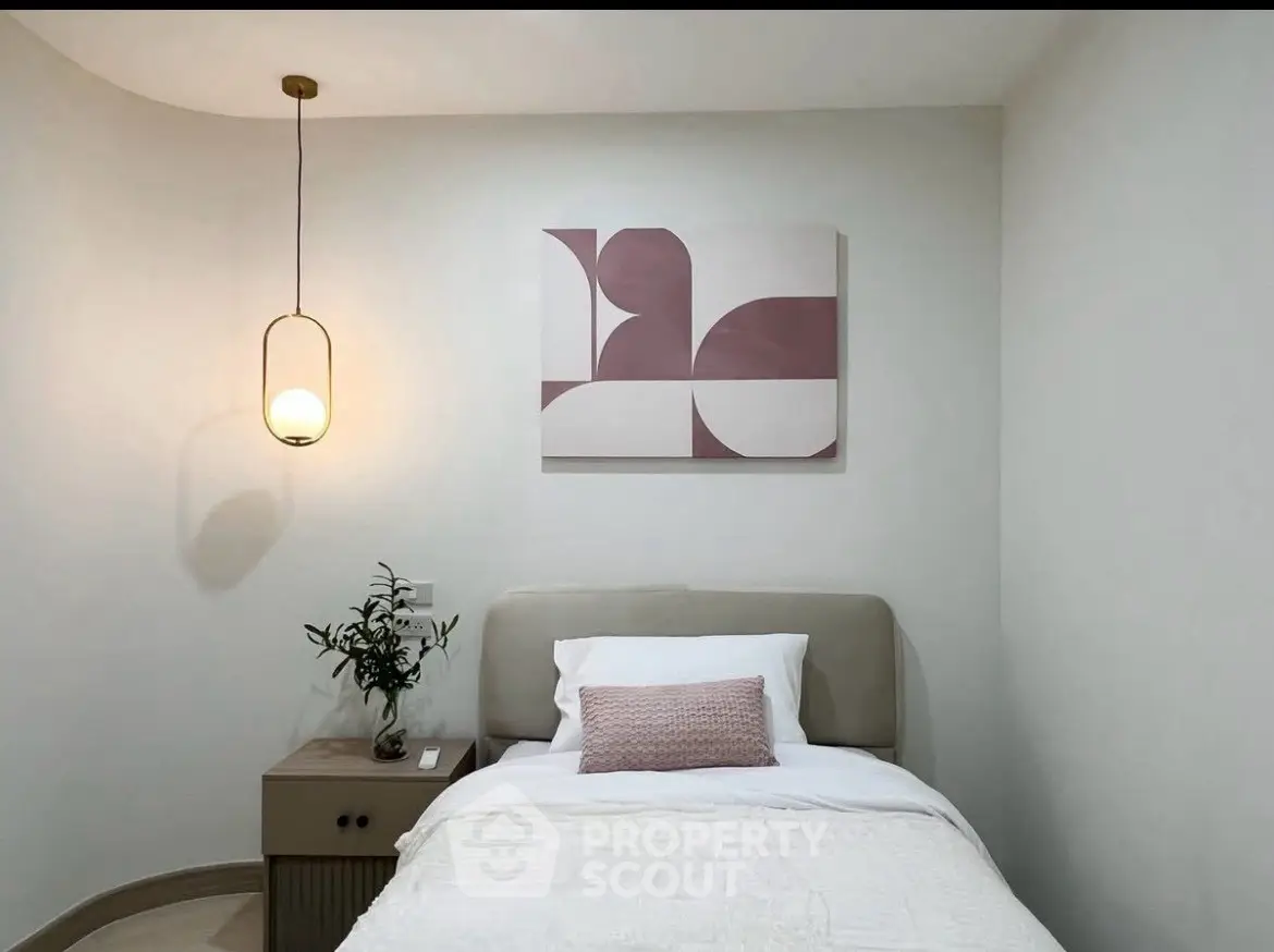 Cozy bedroom with modern decor and stylish lighting, perfect for relaxation.