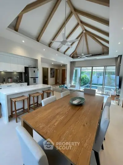 Spacious open-plan living and dining area with high ceilings and modern kitchen in a luxurious home.