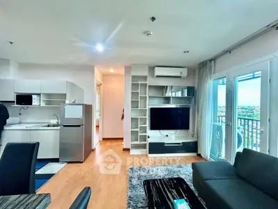 Modern living room with open kitchen and balcony view in a stylish apartment