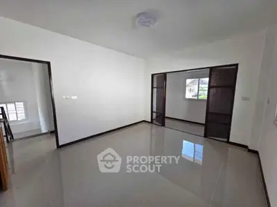 Spacious empty room with glossy tiled floor and large window, perfect for customization.