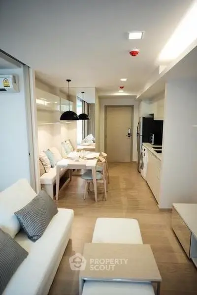 Modern open-plan living room with dining area and kitchen in a stylish apartment.