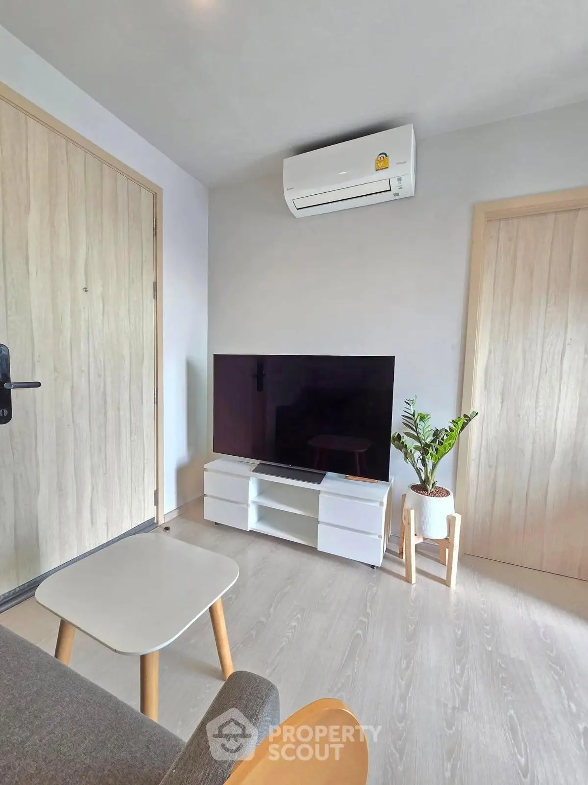 Modern living room with sleek TV setup and air conditioning, perfect for cozy relaxation.