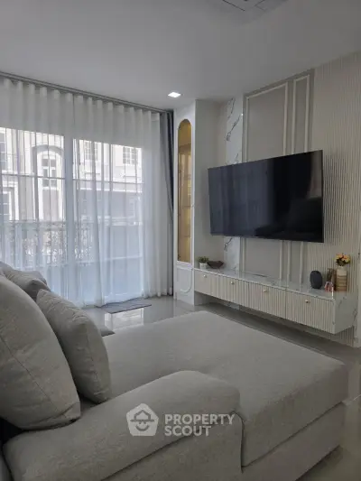 Modern living room with sleek TV setup and large windows