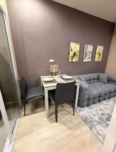 Cozy living room with modern gray sofa and dining area in stylish apartment.