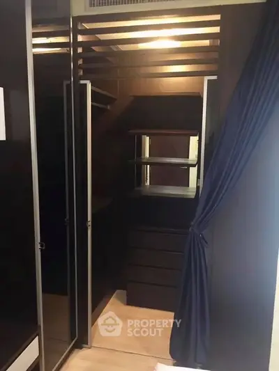 Luxurious walk-in closet with dark wood finish and ample storage space.