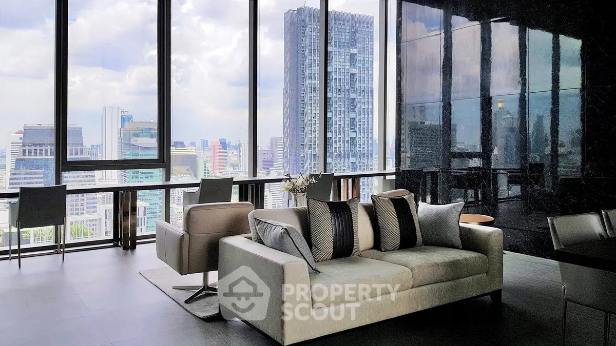 Luxurious living room with panoramic city views and modern furnishings in a high-rise apartment.