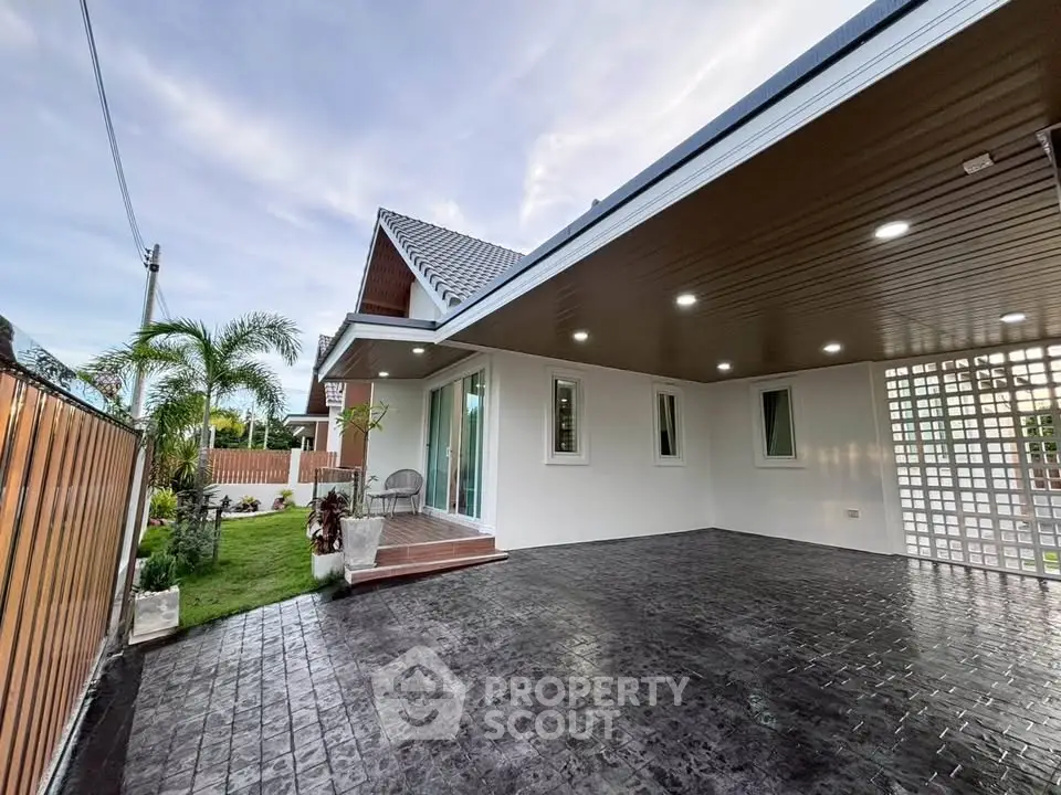 Modern house exterior with spacious driveway and lush garden