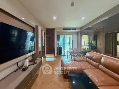 Spacious modern living room with leather sofa and large TV, perfect for relaxation and entertainment.