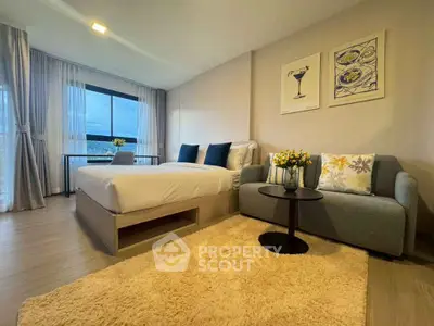 Modern studio apartment with cozy decor and large window view