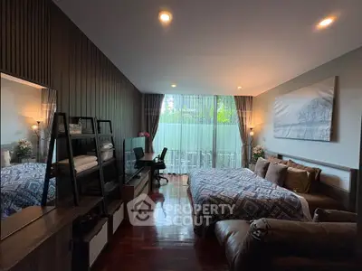 Spacious bedroom with modern decor and large window offering natural light and garden view.