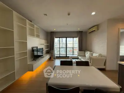Spacious modern living room with city view, featuring sleek furniture and ample natural light.
