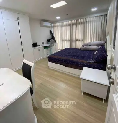 Spacious bedroom with modern furnishings and natural light