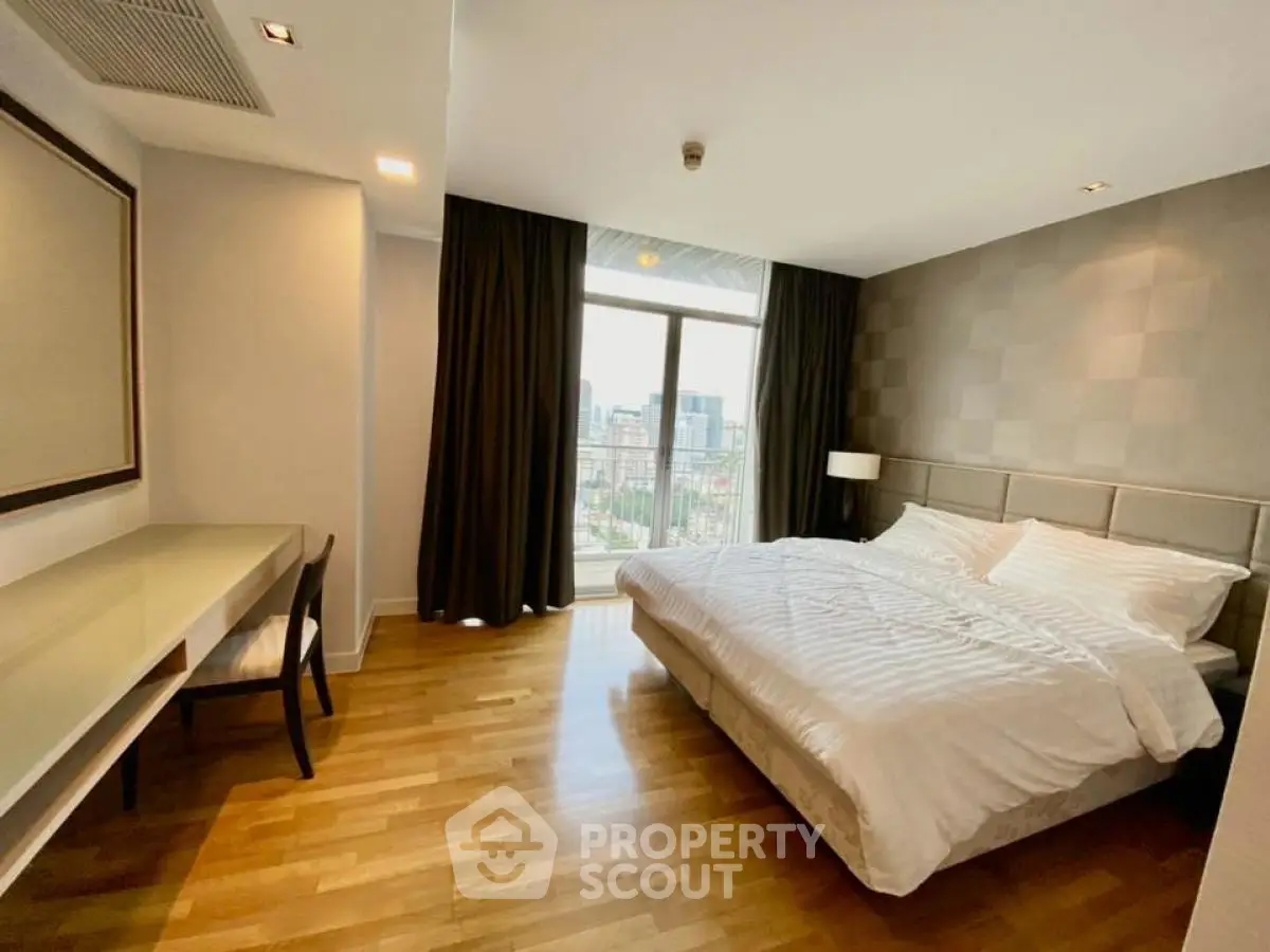 Spacious bedroom with city view, featuring a large bed and elegant decor.