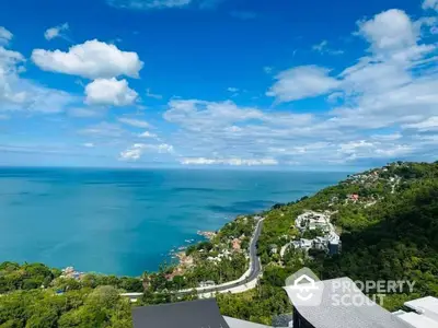 Stunning ocean view from luxury property overlooking lush green hills and coastline.