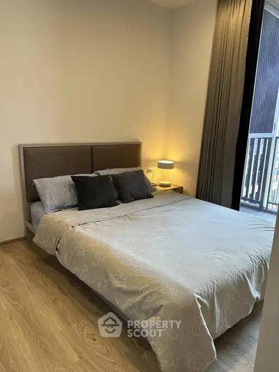Cozy bedroom with modern decor and balcony view, perfect for relaxation and comfort.