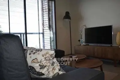 Stylish living room with modern decor and large window for natural light.