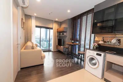 Modern living room with city view, cozy sofa, and sleek kitchen appliances.