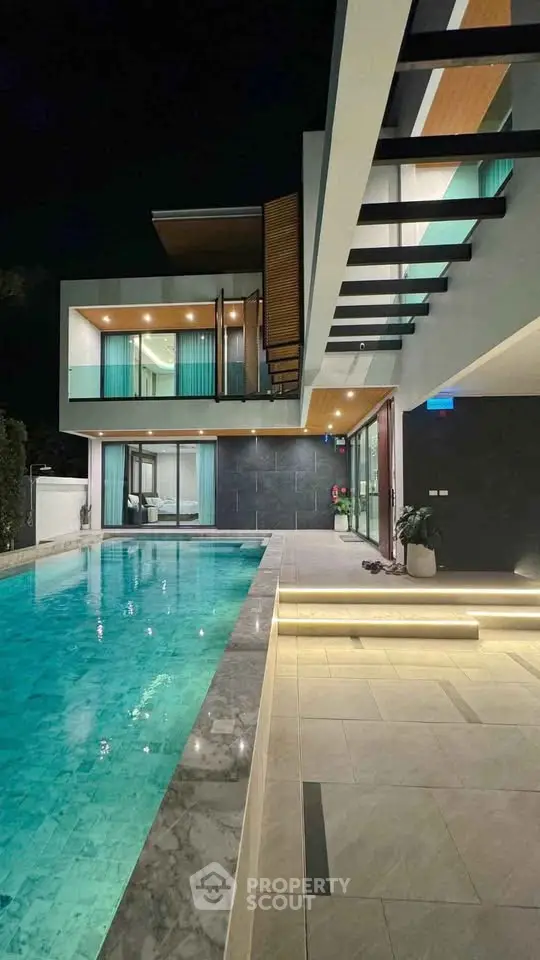 Luxurious modern villa with stunning pool and elegant architecture at night.