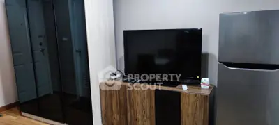 Modern living room with sleek TV and stainless steel fridge
