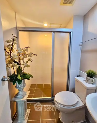 Modern bathroom with shower and elegant decor in real estate property.