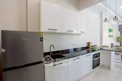 Modern kitchen with sleek white cabinets and stainless steel appliances in a stylish apartment.