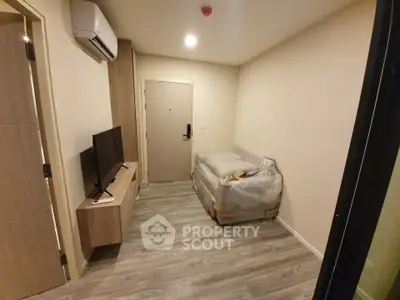 Cozy bedroom with modern furnishings and sleek wooden flooring in a compact apartment.