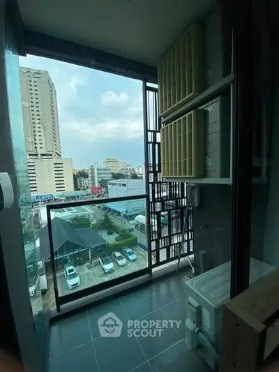 Modern balcony with city view and laundry area in high-rise building.