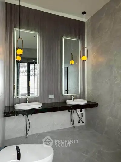 Luxurious modern bathroom with dual sinks and elegant lighting fixtures.