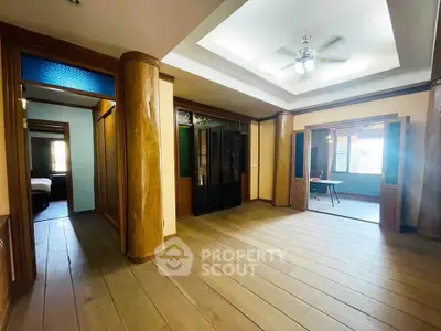 Spacious interior with wooden flooring and ceiling fan, ideal for versatile living space.