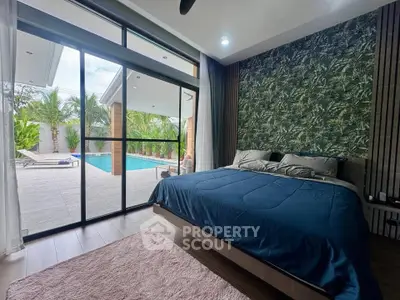 Luxurious bedroom with pool view, featuring modern decor and large sliding glass doors for natural light.