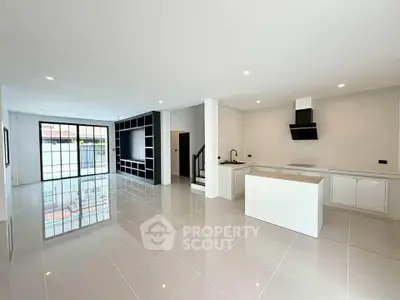 Spacious modern open-plan living room with sleek kitchen and large windows