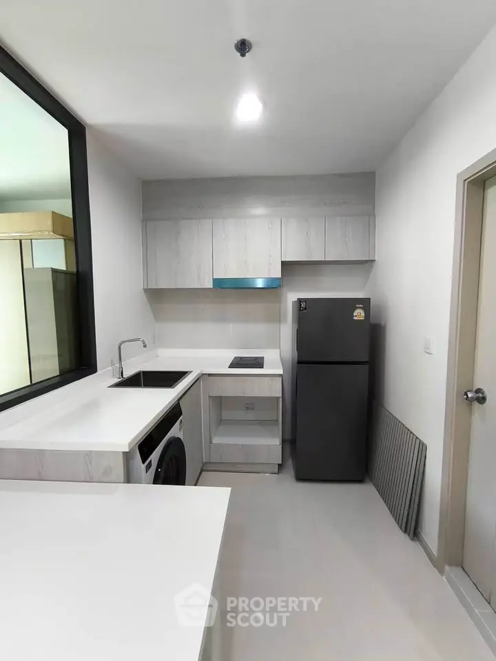 Modern kitchen with sleek appliances and minimalist design in a contemporary apartment.