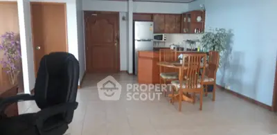 Spacious open-plan living area with kitchen and dining set, ideal for modern living.