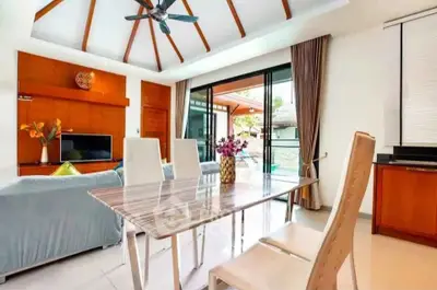 Spacious modern living room with dining area and pool view, featuring elegant decor and natural light.