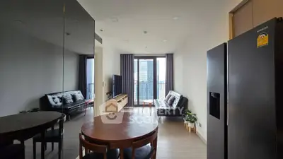Modern living room with city view, sleek furniture, and open layout in high-rise apartment.